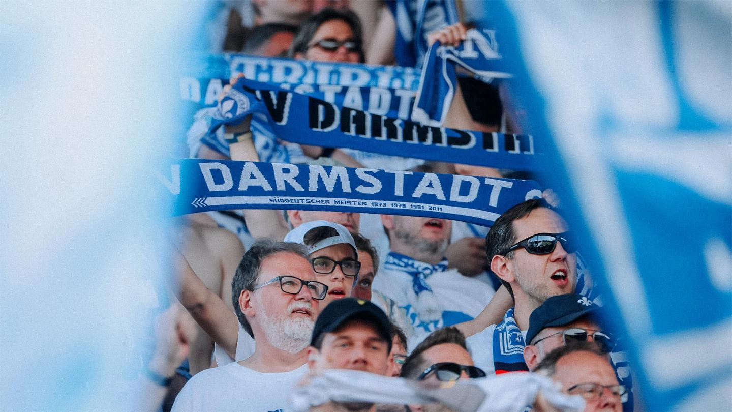 Darmstadt supporters hold up scarves during a game