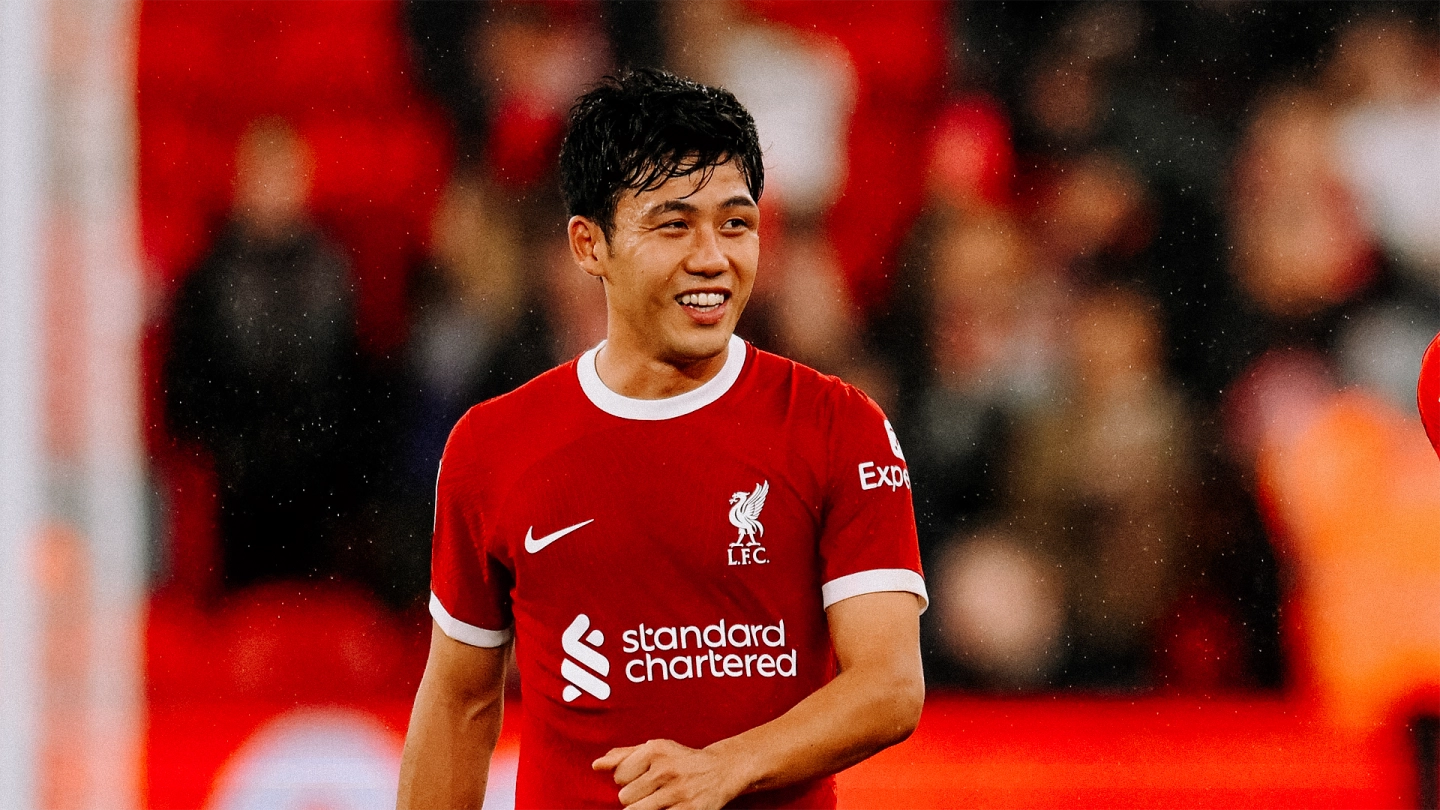 Wataru Endo smiles as he acknowledges fans after a game at Anfield