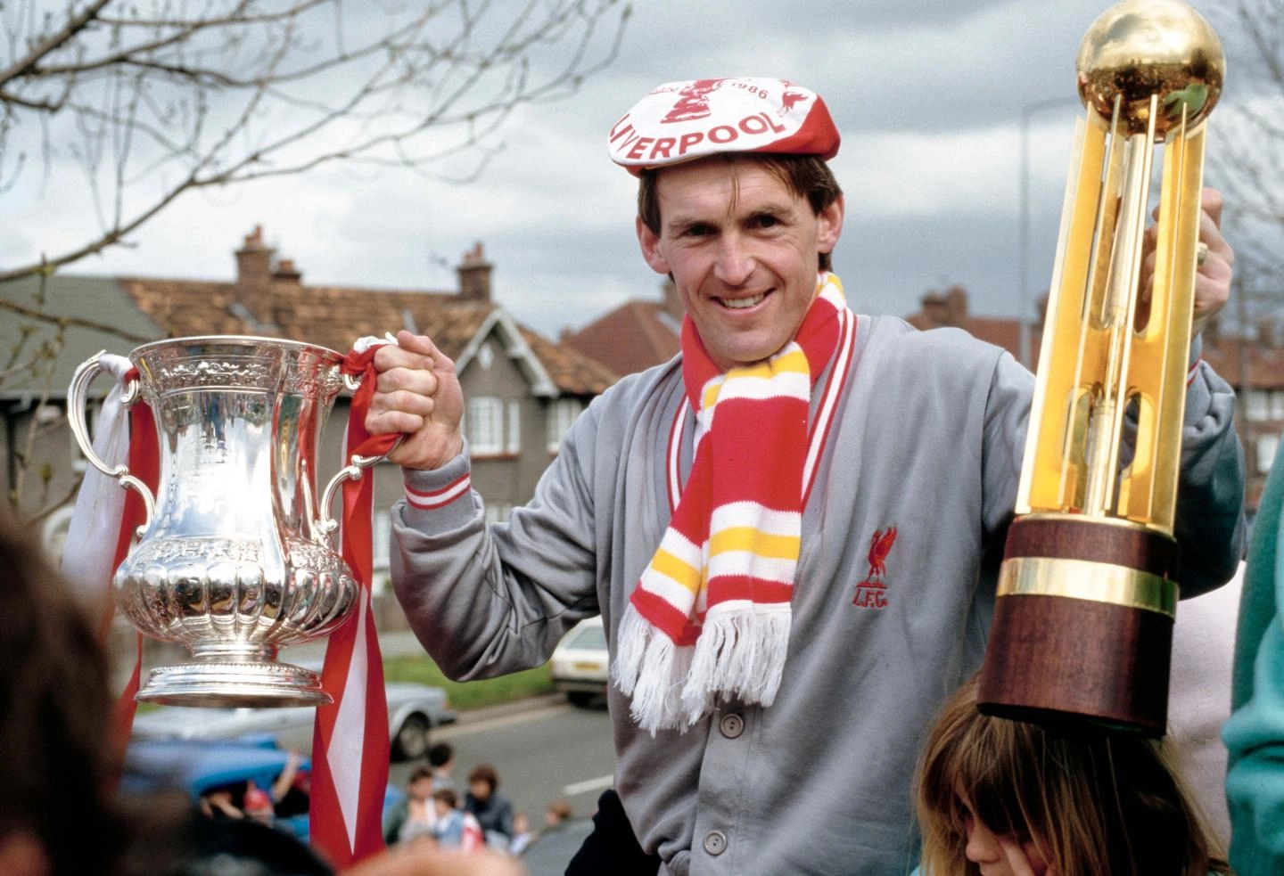 Kenny Dalglish celebrates with the league and FA Cup trophies in 1986