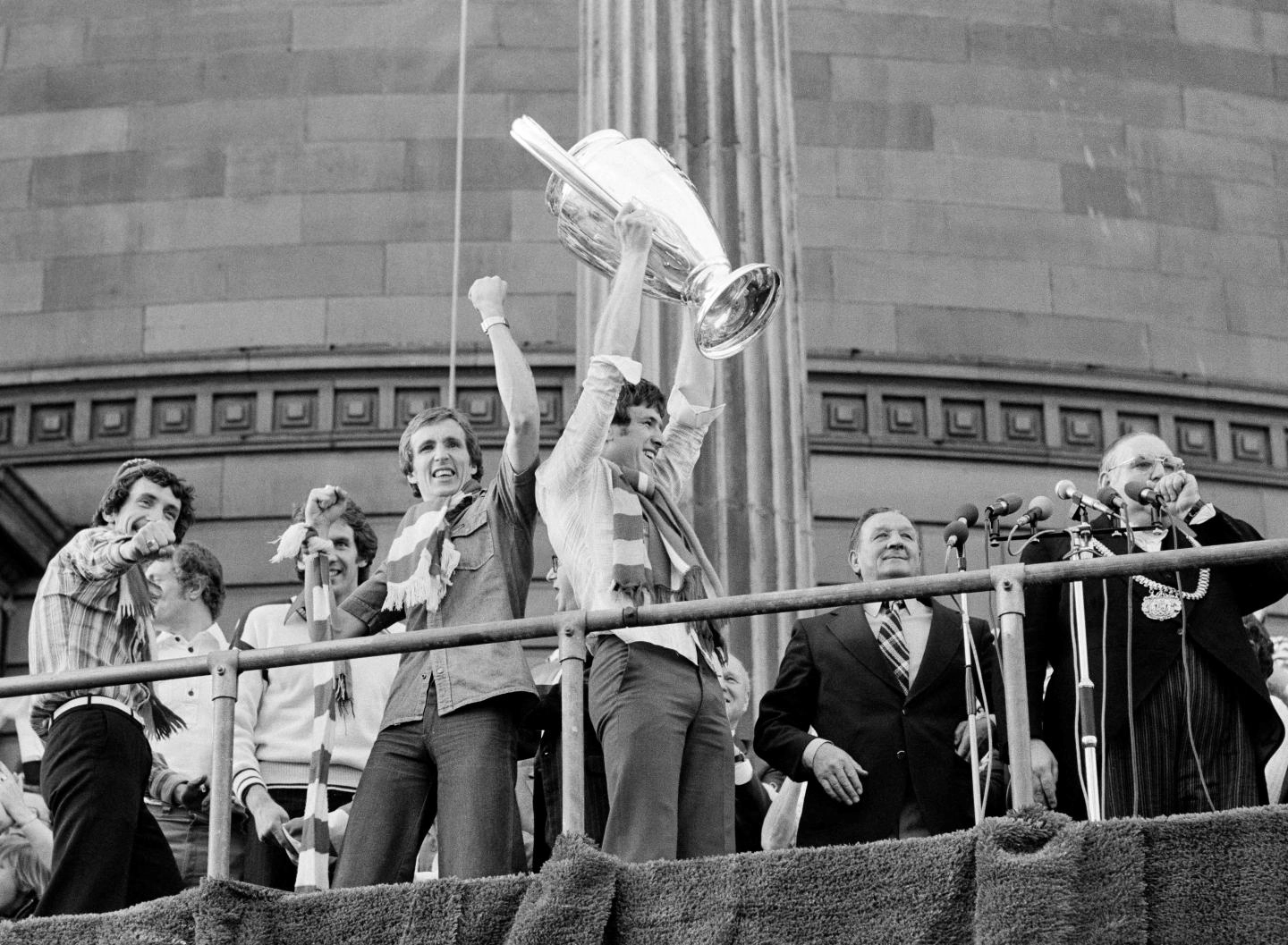 1977: Jones alongside Emlyn Hughes during the civic reception and bus parade following European Cup glory.