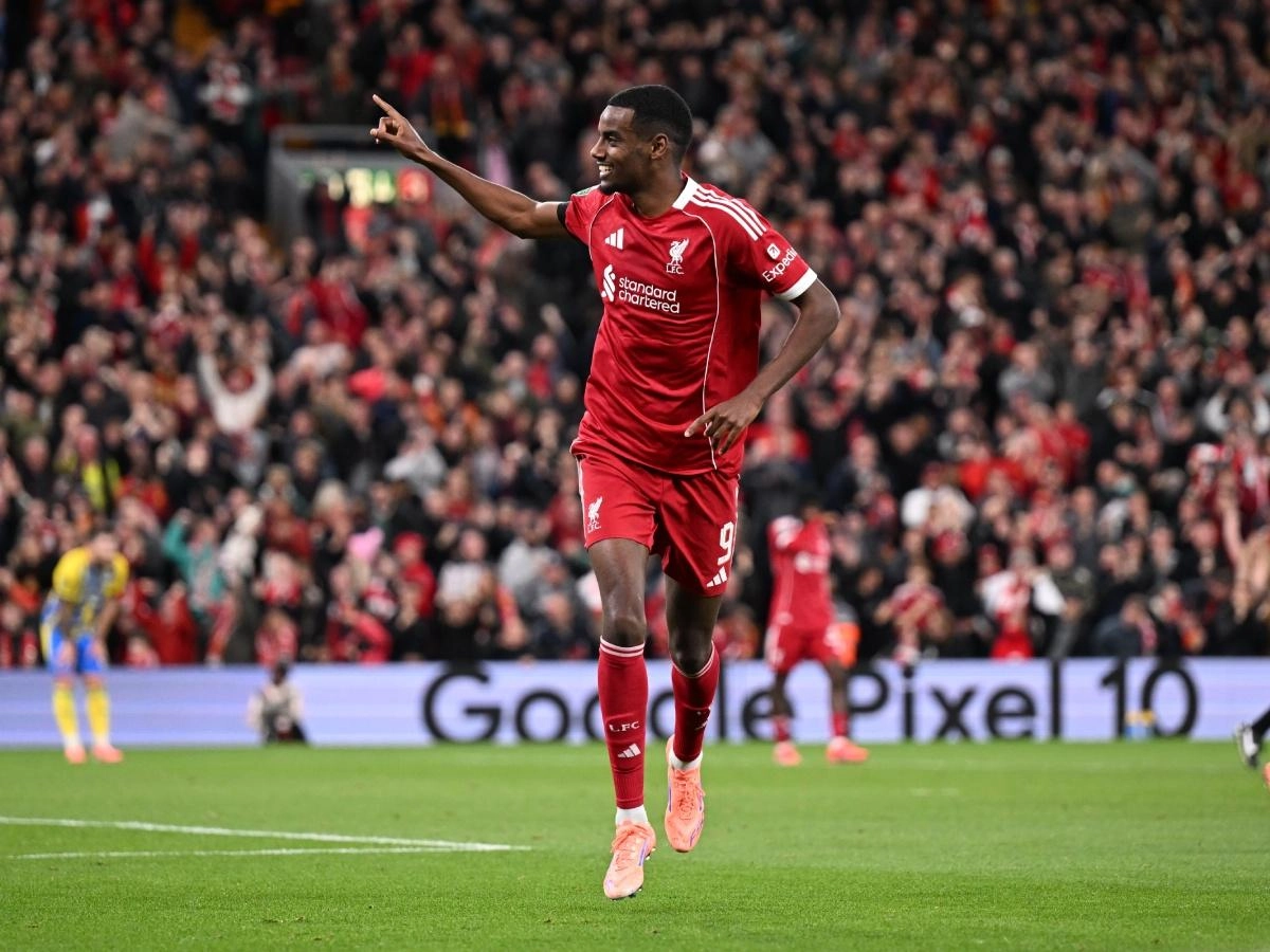 Alexander Isak in a Liverpool home shirt celebrating a goal at Anfield