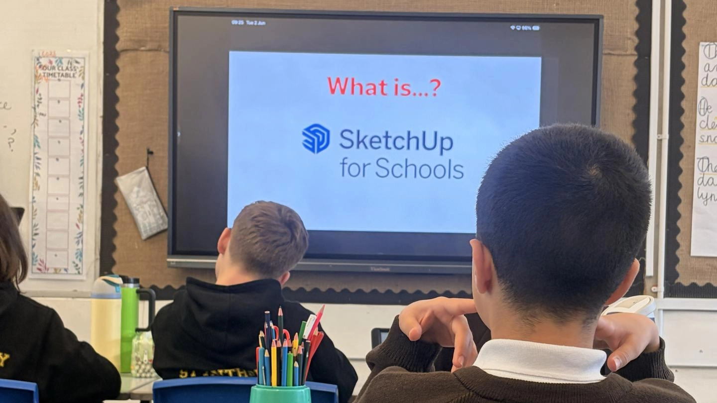 children in a classroom looking at a smartboard