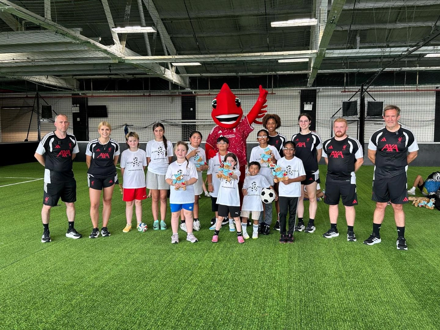 A group of people dressed in sports attire stood on a soccer pitch