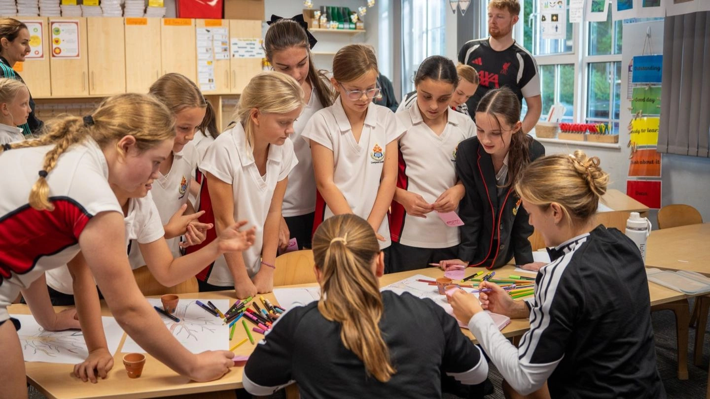beata and cornelia signing notebooks for a group of primary school girls